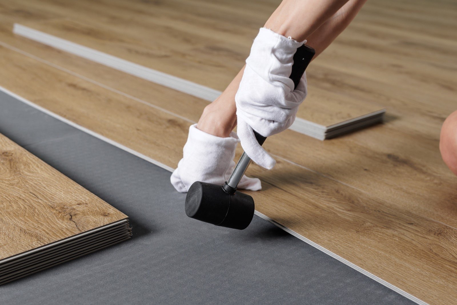 ภาพระยะใกล้ของแผ่นกระเบื้องยาง SPC ระหว่างการเตรียมติดตั้ง